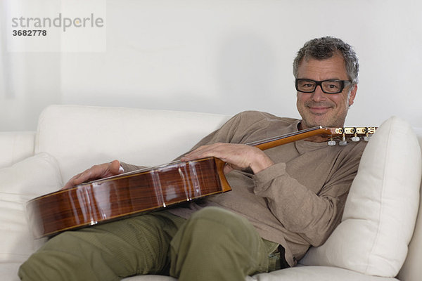 Mann sitzend mit Gitarre