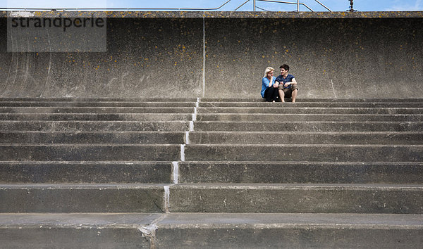 Paar sitzt zusammen auf einer Treppe
