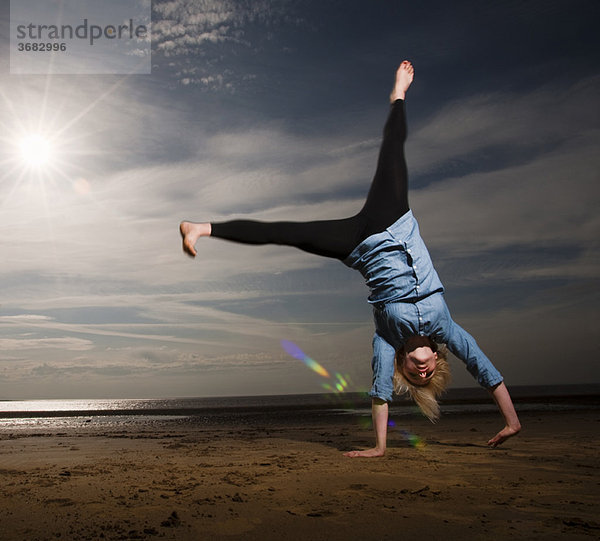 Frau beim Cartwheeling am Strand