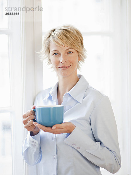 Junge Frau zu Hause mit Pokal