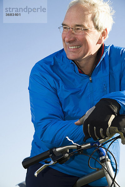 Lächelnder älterer Mann mit Fahrrad