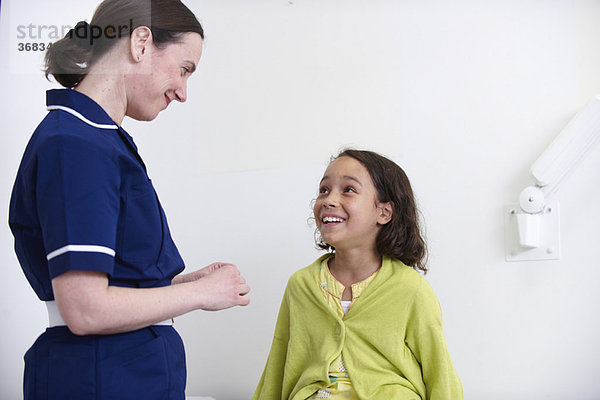 Krankenschwester und junges Mädchen lächelnd