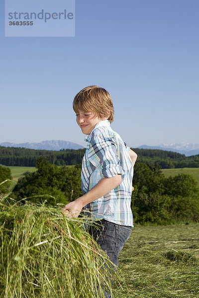 Junge mit Gras auf der Gabel  arbeitend