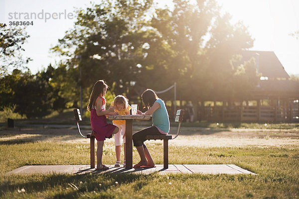 3 Mädchen sitzend in der Parkmalerei