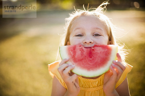 Junges Mädchen lächelt mit Wassermelone