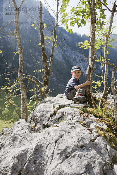 Junge auf einem Stein sitzend