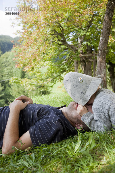 Junge mit Hut  der seinen Vater kuschelt