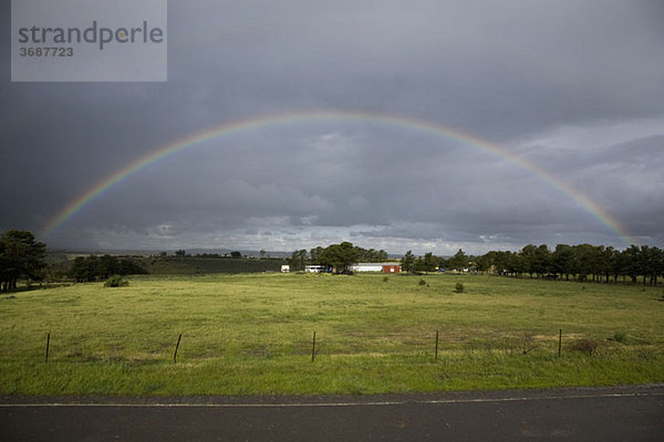 Ein Regenbogen am Himmel über einer ländlichen Umgebung