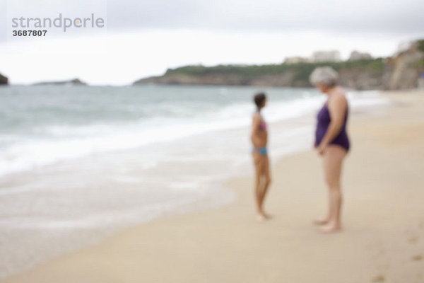 Eine Mutter und Tochter am Strand  defokussiert.