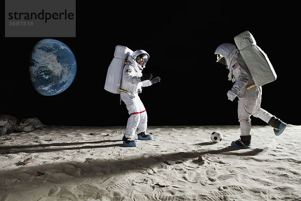 Zwei Astronauten beim Fußball auf dem Mond