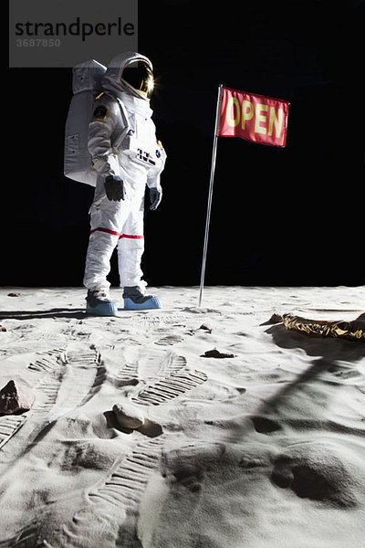 Ein Astronaut auf dem Mond neben einer Fahne mit OPEN drauf.