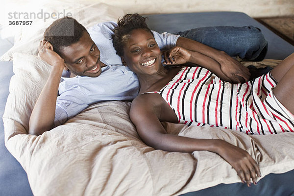 Ein junges Paar entspannt im Bett