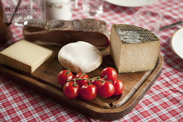 Käse  Tomaten und Rohschinken auf einem Holzschneidebrett