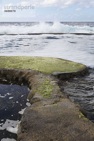 Detail eines steinernen Steges im Meer