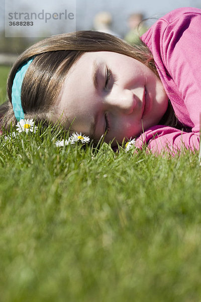 Detail eines auf Gras liegenden Mädchens
