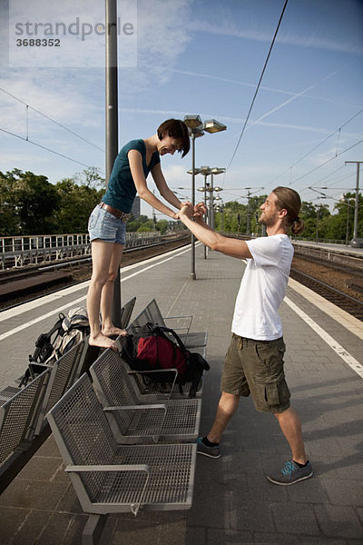 Ein junges Paar beim Warten auf dem Bahnsteig