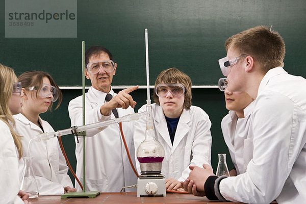 Ein Lehrer  der seinen Schülern ein Chemie-Experiment zeigt.