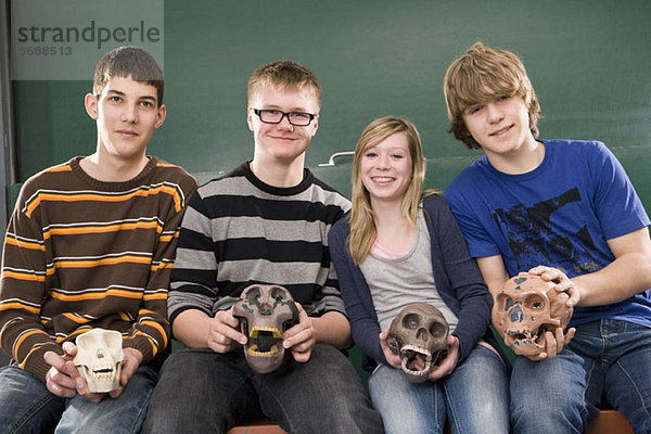 Vier Schüler mit Primatenschädeln im Biologieunterricht  Portrait