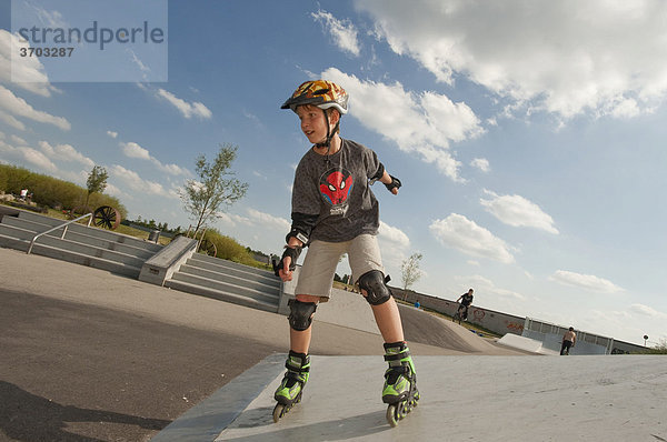 Junge  11 Jahre  mit Rollerblades und Schutzausrüstung im Funpark