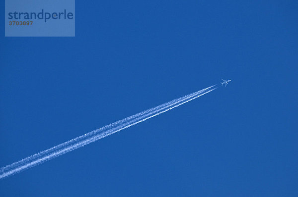 Flugzeug mit mehrstrahligem Kondensstreifen am blauen Himmel