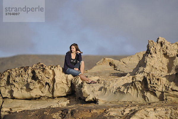 Junge Frau auf Kalkgesteinsablagerungen  La Pared  Fuerteventura  Kanarische Inseln  Spanien  Europa