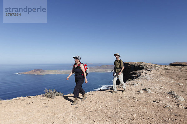 Wanderer auf Risco de Famara nahe Guinate  hinten Insel La Graciosa  Lanzarote  Kanaren  Kanarische Inseln  Spanien  Europa