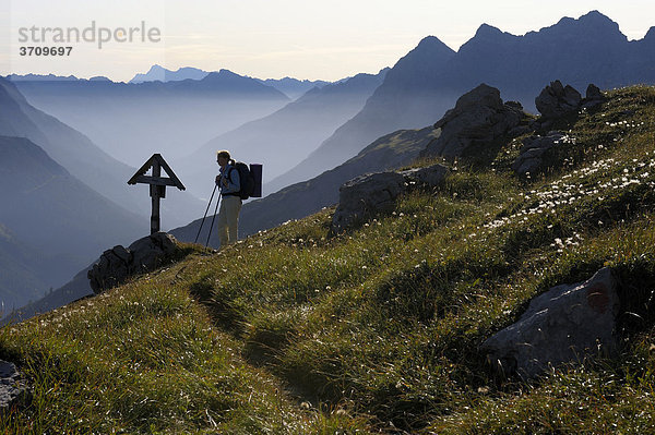 Bergsteigerin vor Gedenkkreuz im Morgenlicht  Hinterhornbach  Lechtal  Außerfern  Tirol  Österreich  Europa