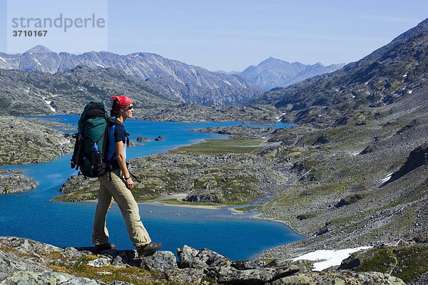 Junge Frau genießt das Panorama auf dem Gipfel des historischen Chilkoot Pfad  Chilkoot Pass  dahinter der See Crater Lake  alpine Tundra  Yukon Territory  British Columbia  B.C.  Kanada