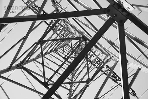Blick von unten nach oben in einen Strommasten  schwarz-weiß