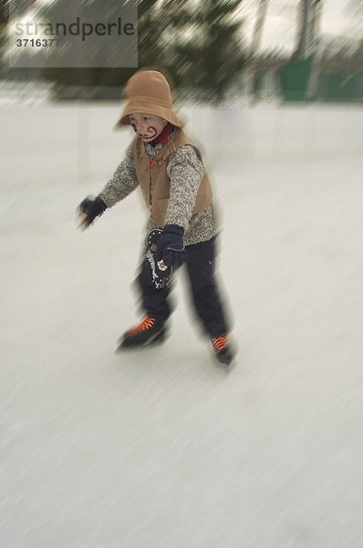 Kleiner Junge beim Eislaufen als Cowboy verkleidet