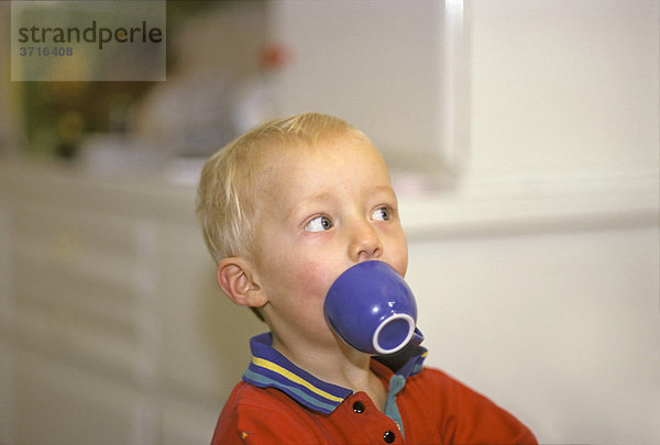 1  5 Jahre altes Kind Bub macht Spaß mit einer Tasse vorm Mund