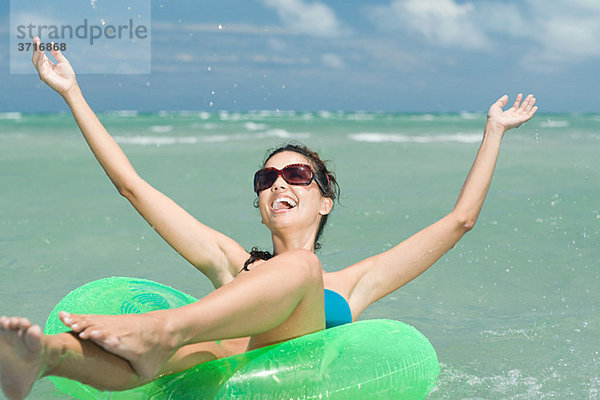 Glückliche Frau im Meer auf dem aufblasbaren Ring