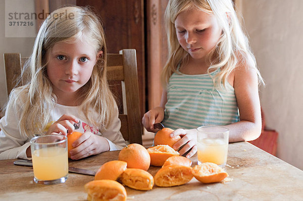 Mädchen machen frischen Orangensaft