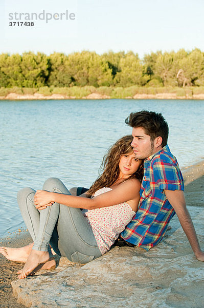 Junges Paar am See sitzend