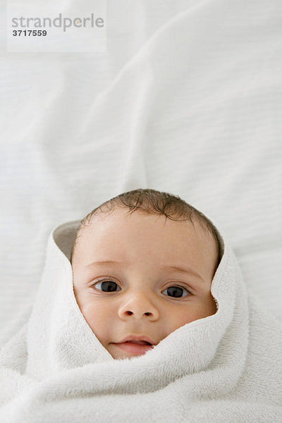 männliches Baby eingewickelt in ein Handtuch