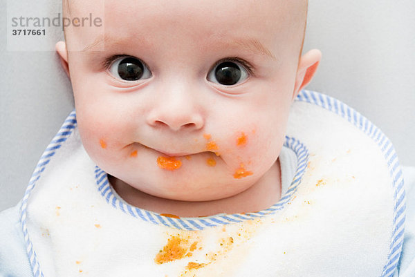 Baby mit Essen im Gesicht