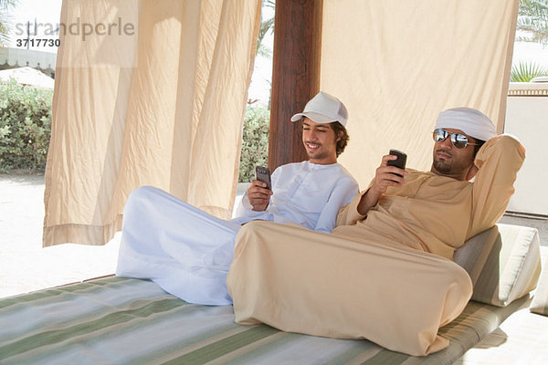 Zwei Nahen Ostens Männer sitzen auf dem Bett