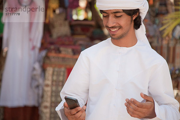 Mann aus dem Nahen Osten schaut aufs Handy