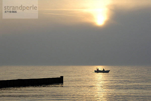 Zwei Angler in einem Boot auf der Ostsee am Abend