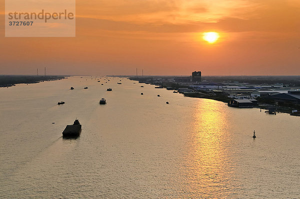 Transportschiffe fahren im letzten Abendlicht in den Sonnenuntergang am Mekong  My Tho  Mekongdelta  Vietnam  Asien