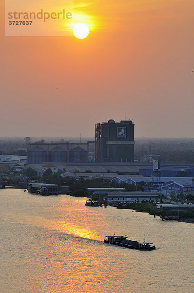 Transportschiff und Fabrik bei Sonnenuntergang am Mekong  Can Tho  Mekongdelta  Vietnam  Südostasien