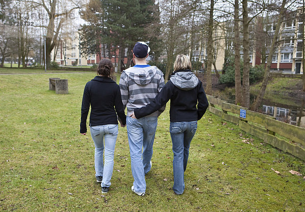 Drei Teenager  Rückenansicht  unentschlossene Jugend beim Spaziergang
