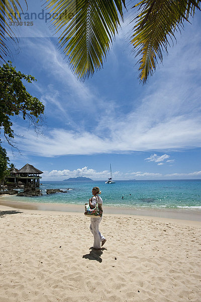 Frau läuft am Strand bei Glacis  Insel Mahe  Seychellen  Indischer Ozean  Afrika