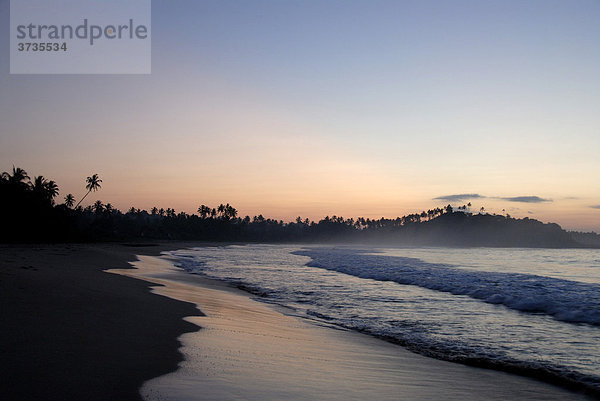 Morgenrot am Meer  seichte Wellen am Sandstrand am frühen Morgen  Talalla bei Dondra  Indischer Ozean  Ceylon  Sri Lanka  Südasien  Asien