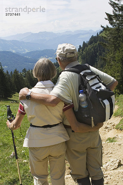 Älteres Paar genießt Aussicht beim Wandern  Berge  Rucksack  Wanderstöcke  Hochgrat  Deutschland  Europa