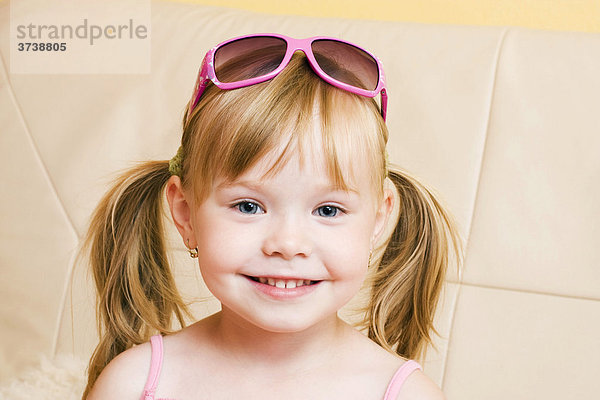 Lächelndes blondes kleines Mädchen  mit Sonnenbrille  4 Jahre