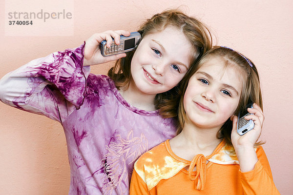 Zwei Mädchen 9 und 6 Jahre alt  telefonieren