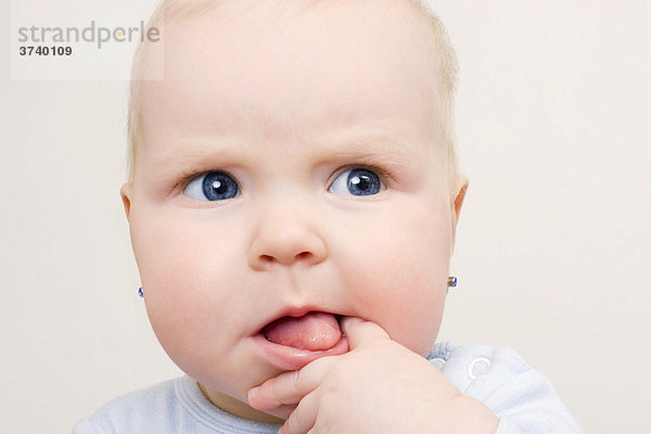 Baby runzelt die Stirn  7 Monate  mit Finger im Mund