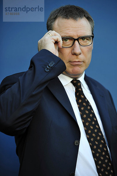 Mann  45-50 Jahre  Portrait  setzt Brille auf  Anwalt in Anzug  Businessman