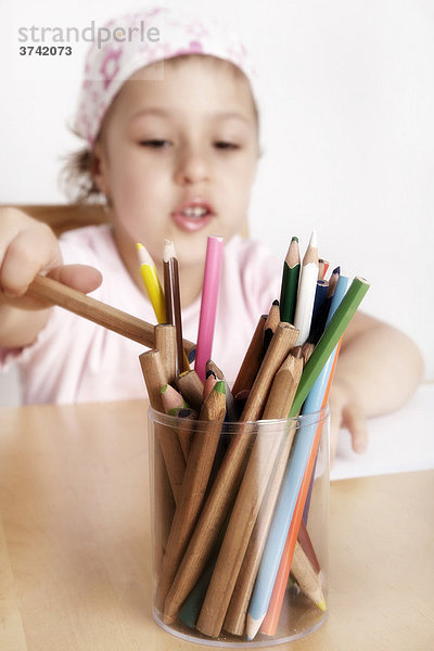 6jähriges Mädchen sitzt malend am Schreibtisch